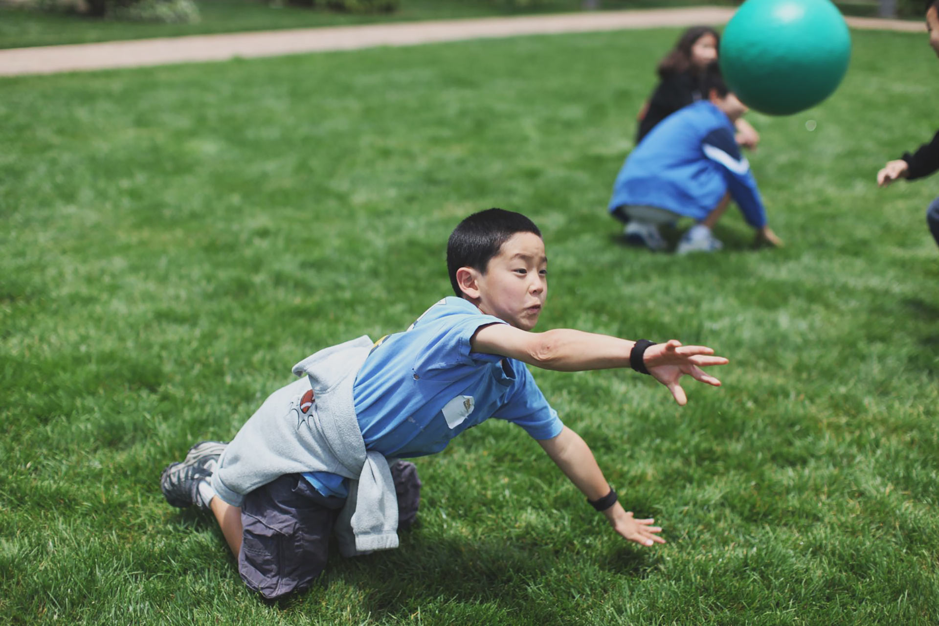 PlanetBravo campers playing a ball game together on the grass